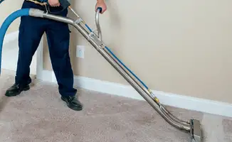 Professional operating a liquid removal machine on a carpeted floor in Lowell, MA